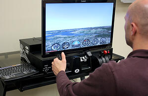 A pilot flying a Redbird Jay all-in-one training device