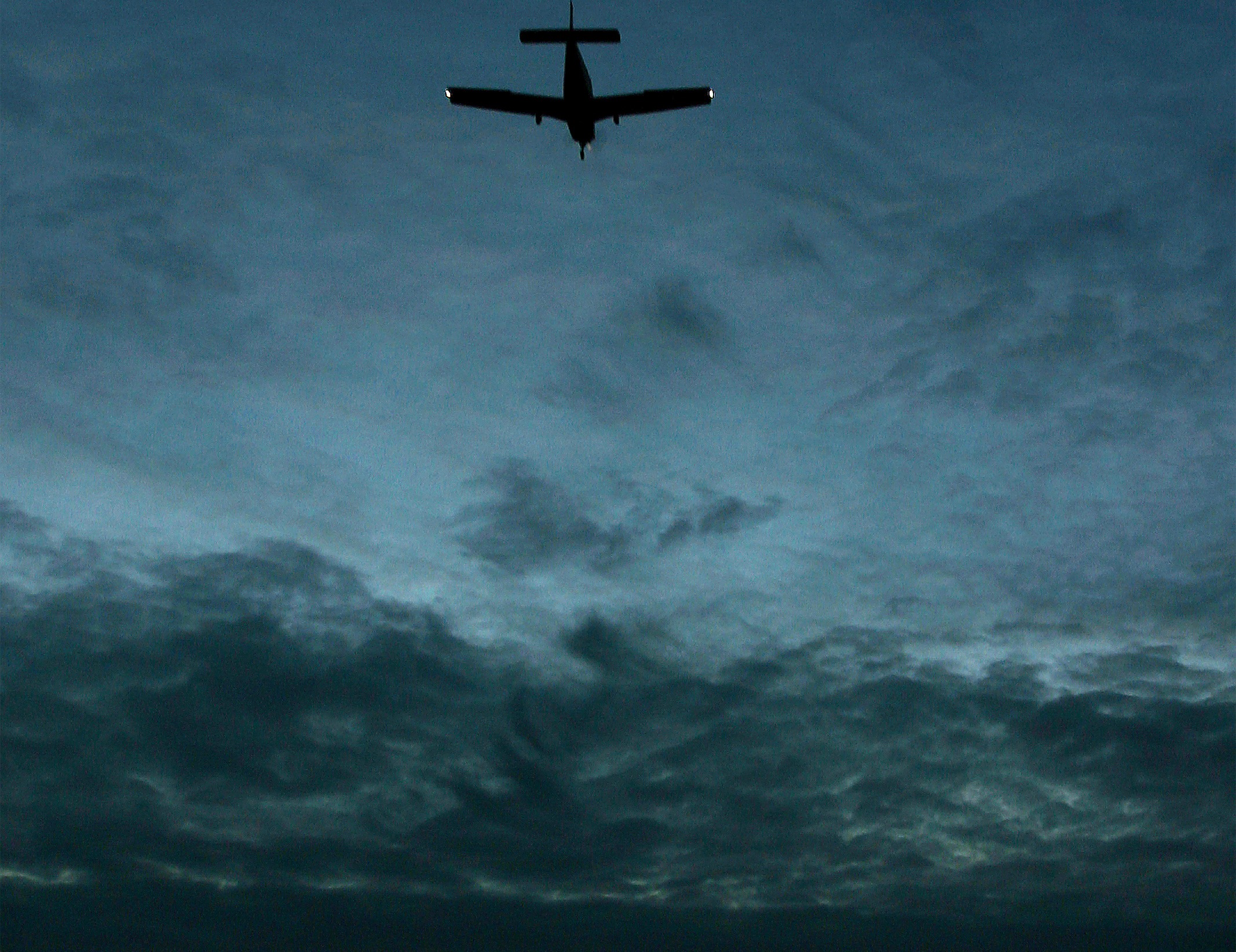 GA airplane flying through a cloudy night sky