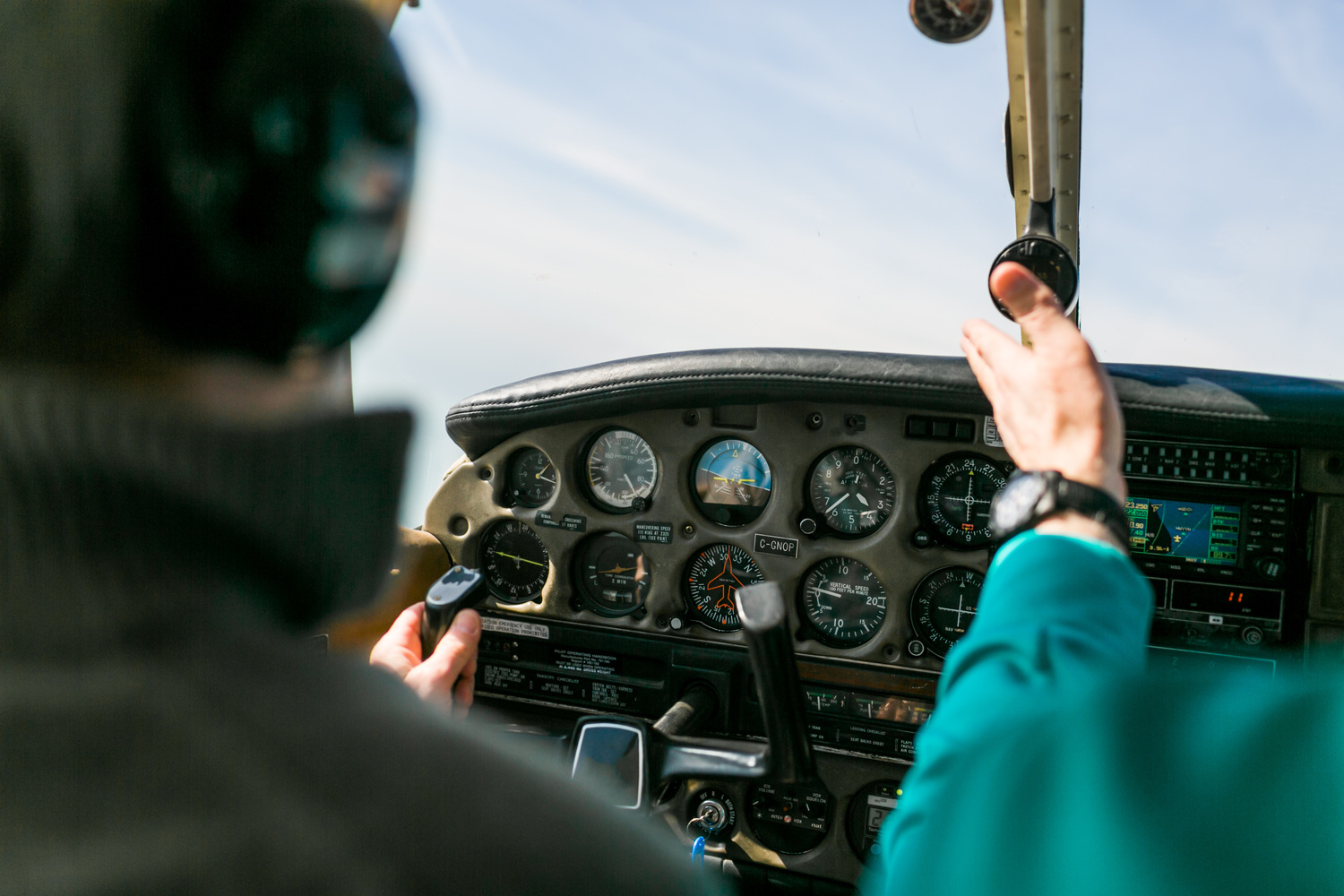 CFI instructing student pilot from the right seat of a training aircraft in the air