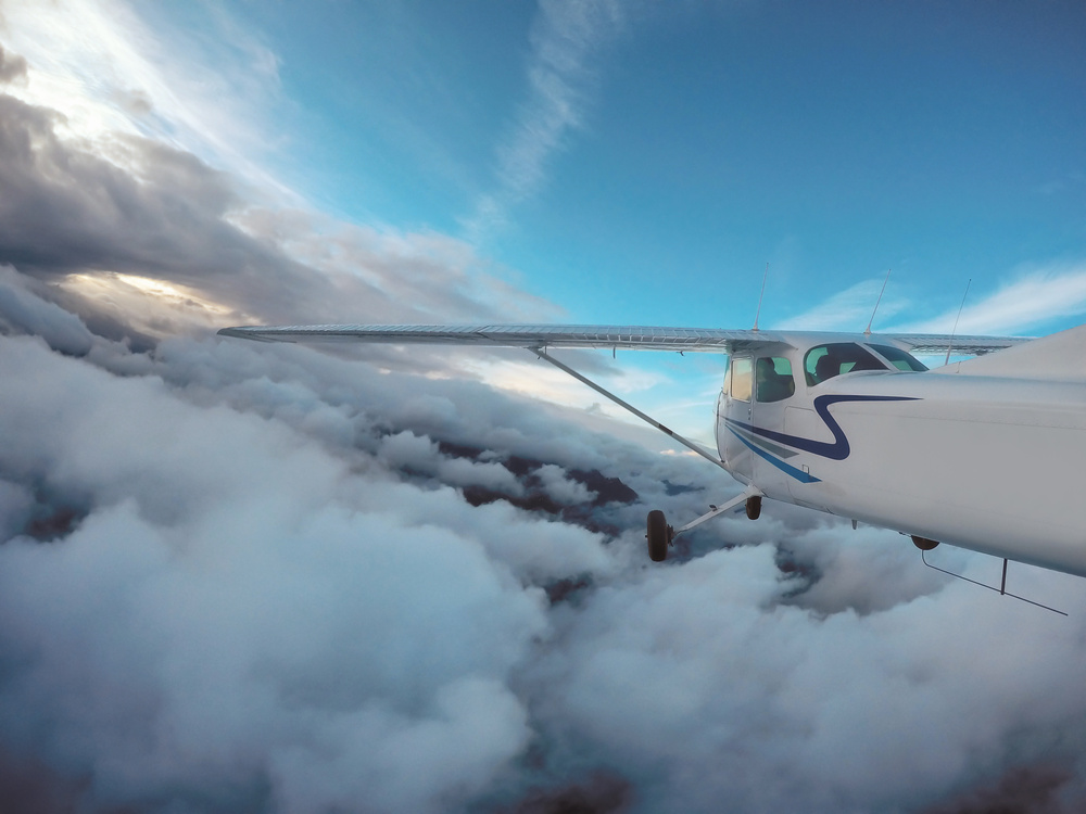 High-wing airplane flying into the clouds