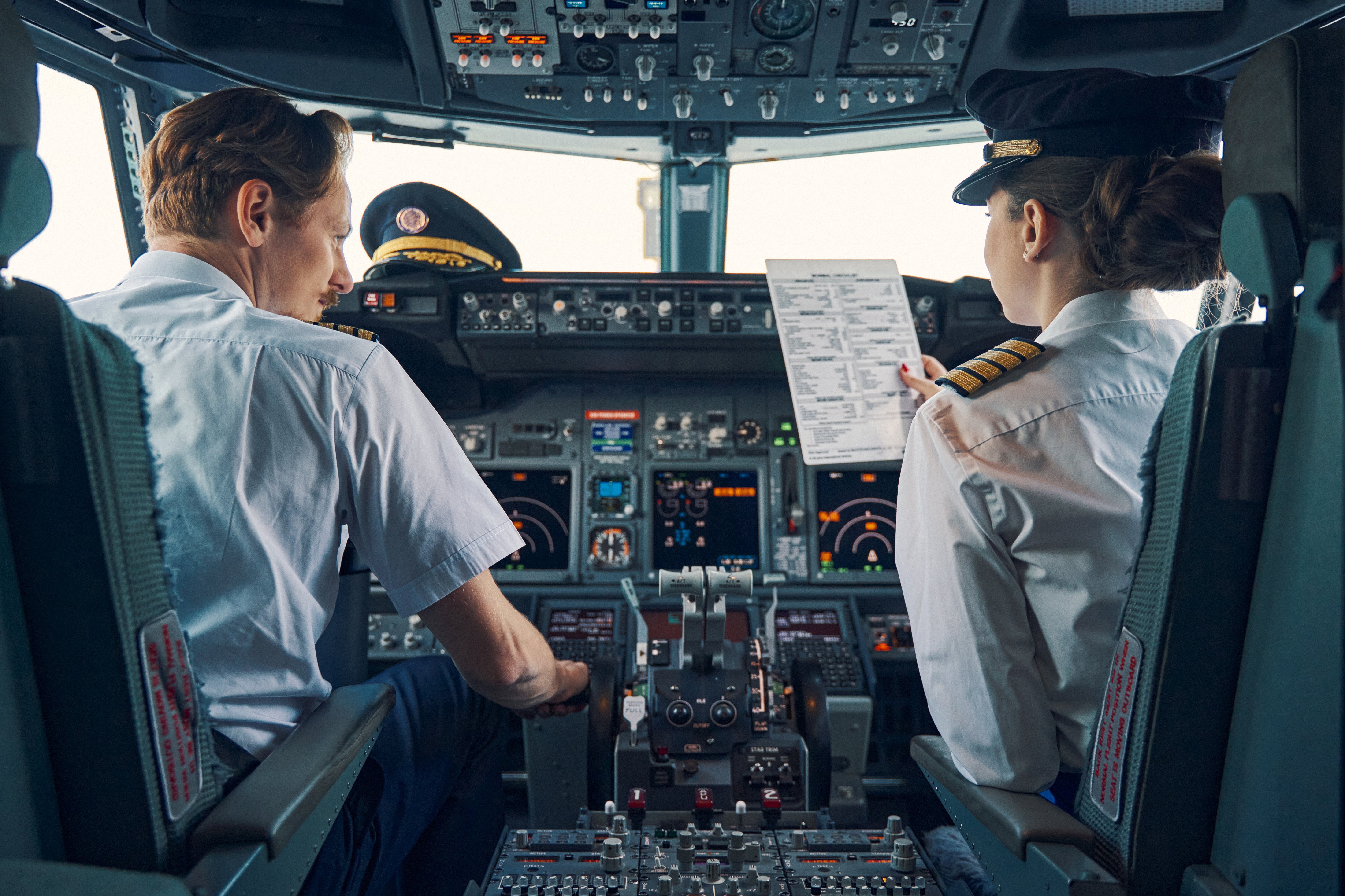 Airline pilots going through checklist on the flight deck