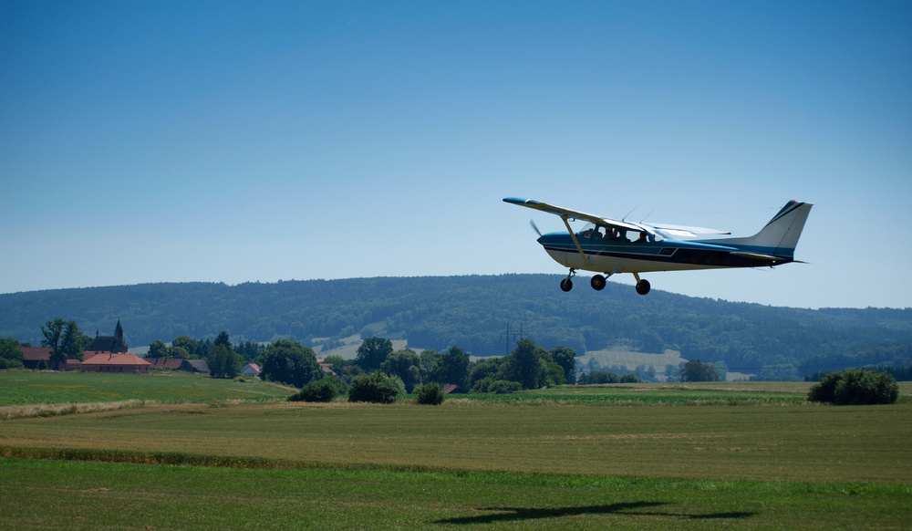 High-wing airplane going around at a rural airport