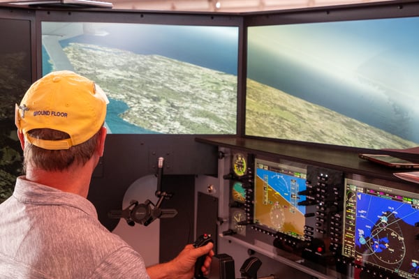A pilot flying VFR in a Redbird flight simulator at EAA AirVenture Oshkosh 2021