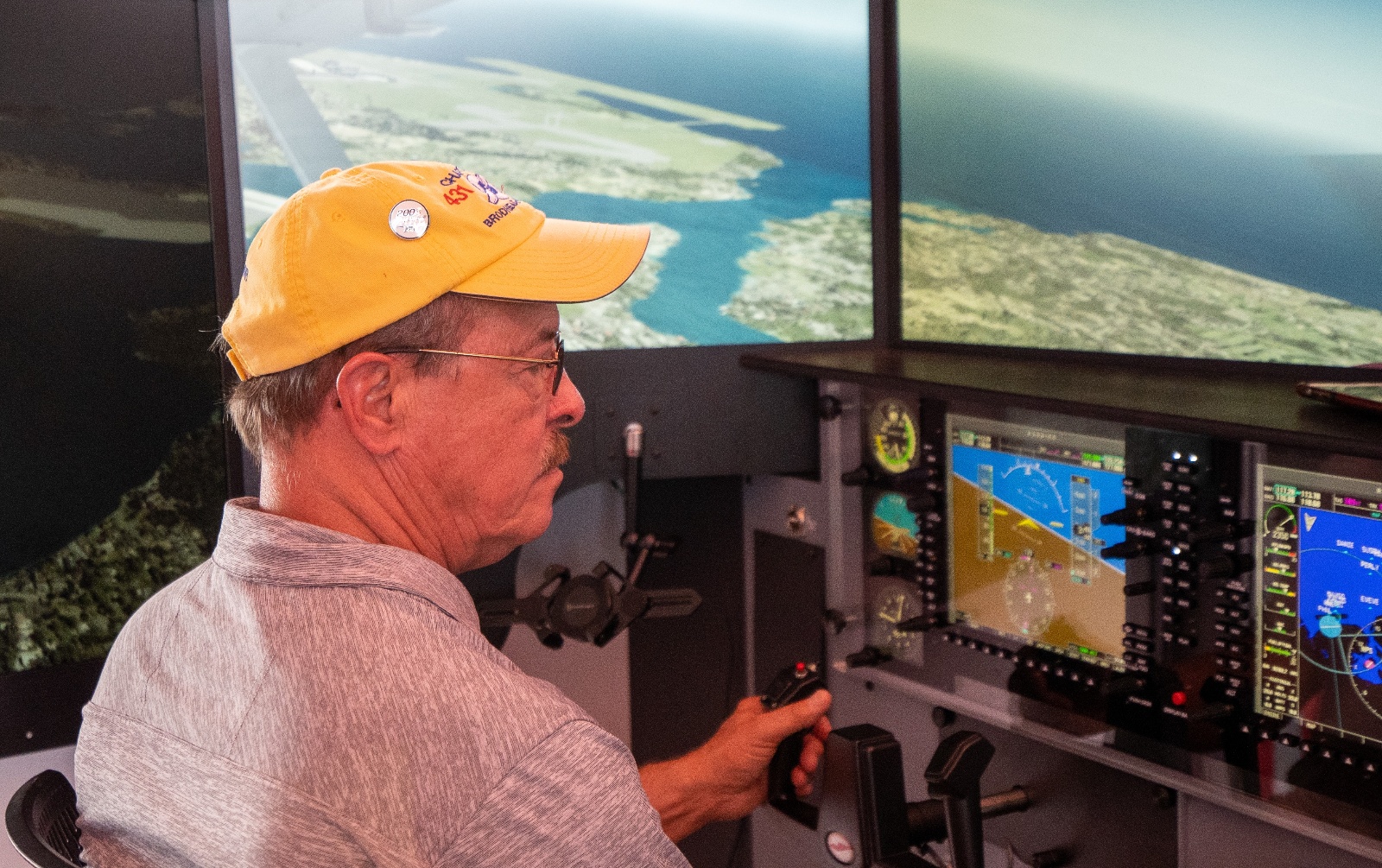 Pilot flying a scenario over the coast on a Redbird LD advanced aviation training device