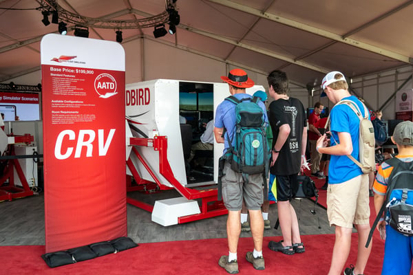AirVenture attendees stand in line to fly a Redbird full-motion flight simulator