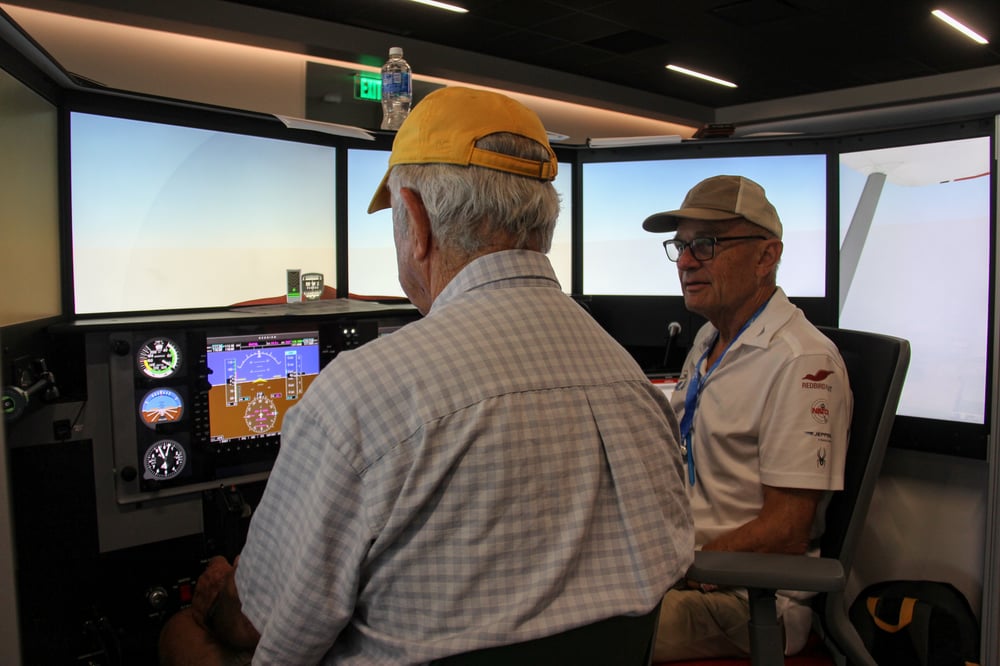 Pilot and CFI using a Redbird AATD in the Pilot Proficiency Center at EAA AirVenture
