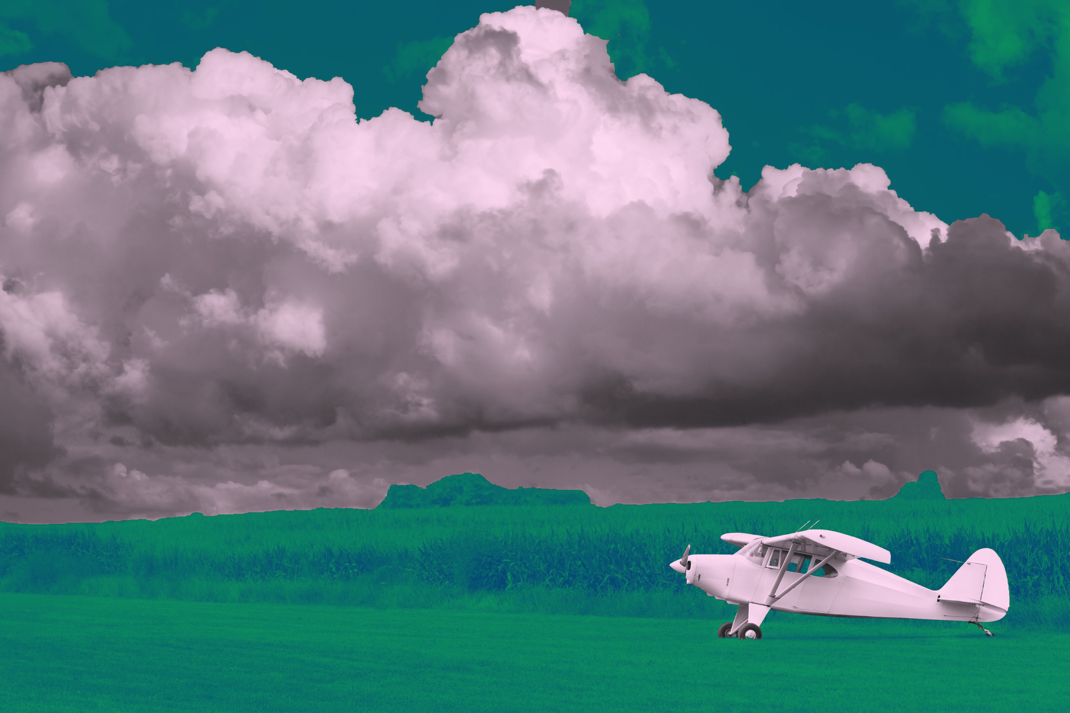 Tailwheel on grass strip with storm clouds overhead