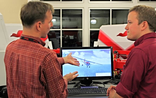 Flight instructor and student pilot debriefing a flight simulator scenario at a flight school