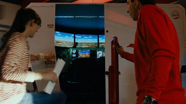 Flight instructor and student pilot entering a flight simulator for flight training