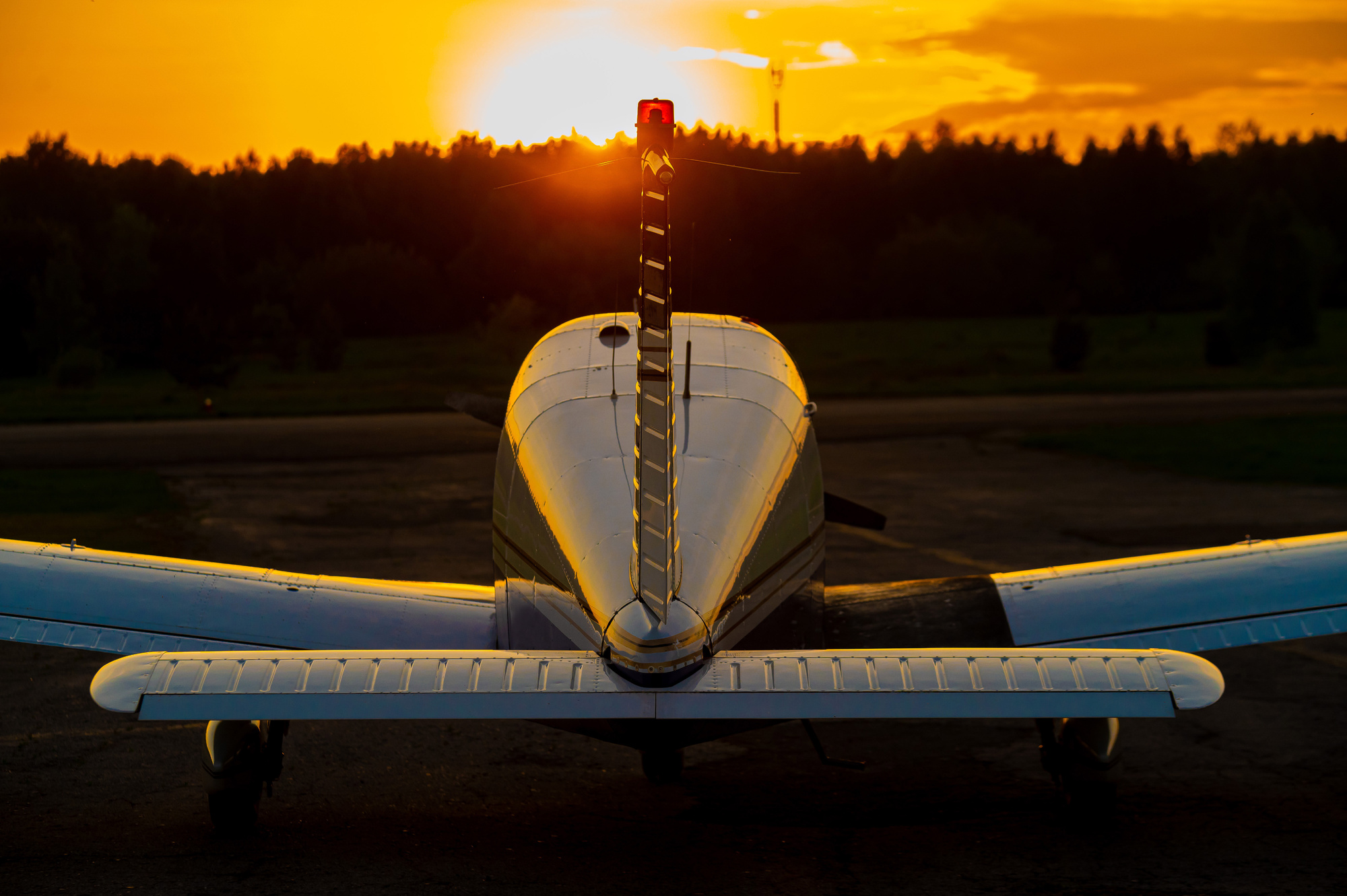 Airplane parked on ramp at sunset