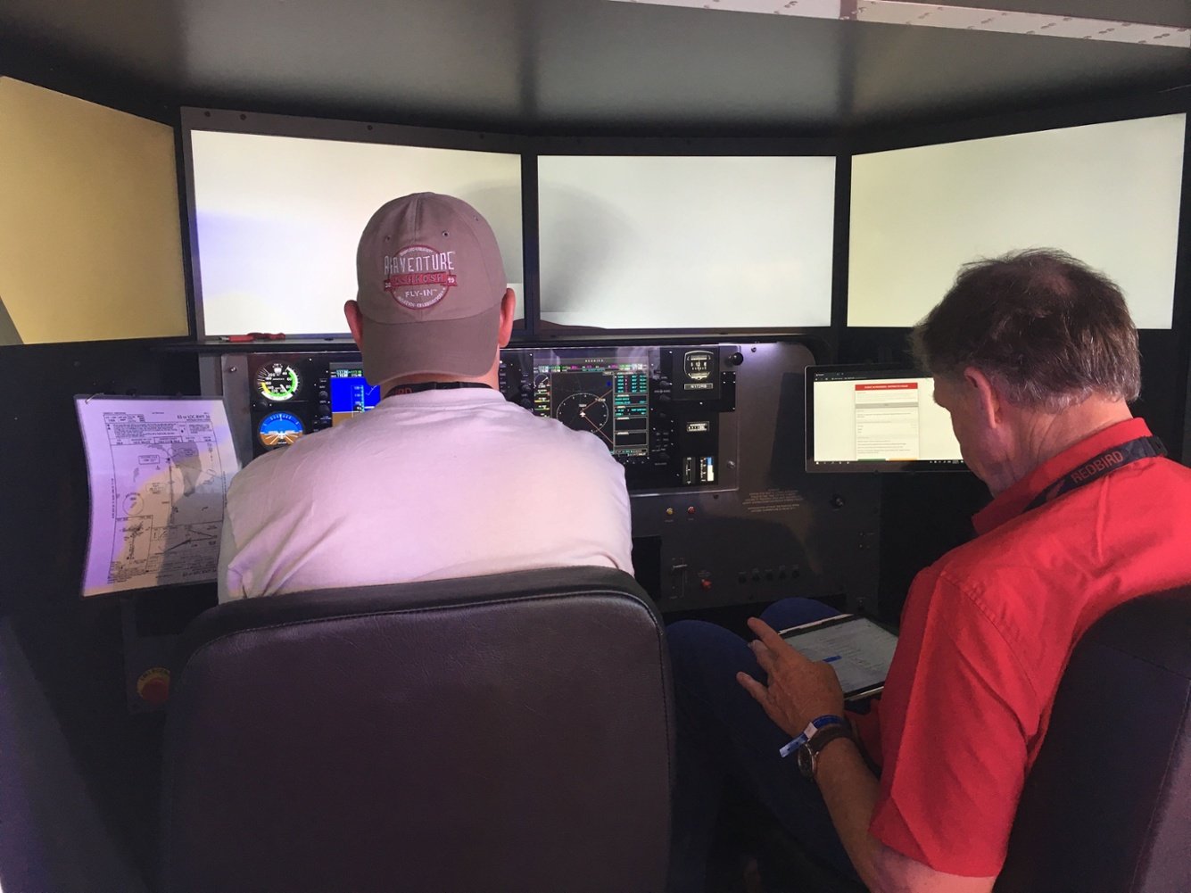 Flight instructor adjusts the weather conditions during an IFR training session in a Redbird simulator