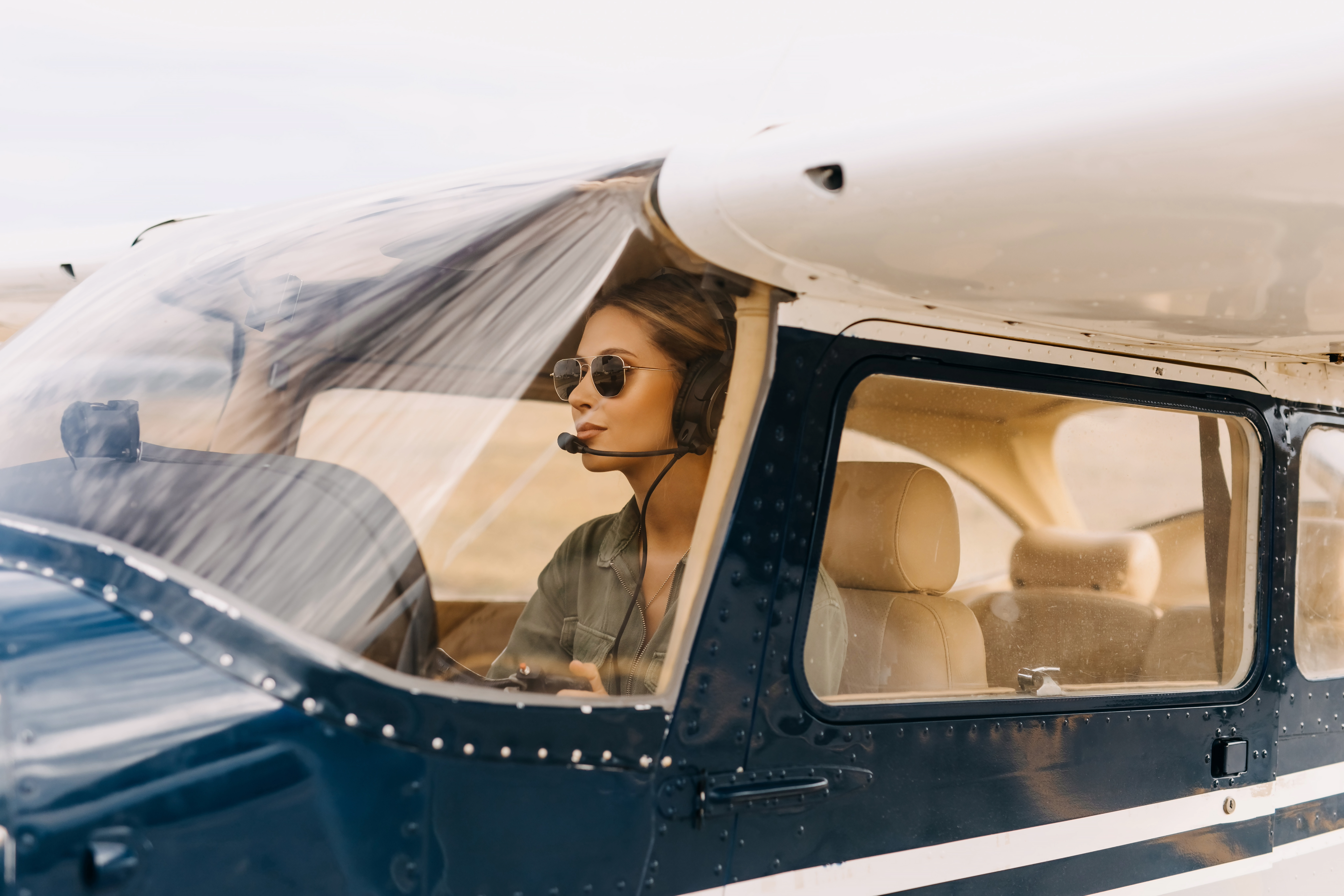 GA pilot taxiing outwearing an aviation headset and sunglasses