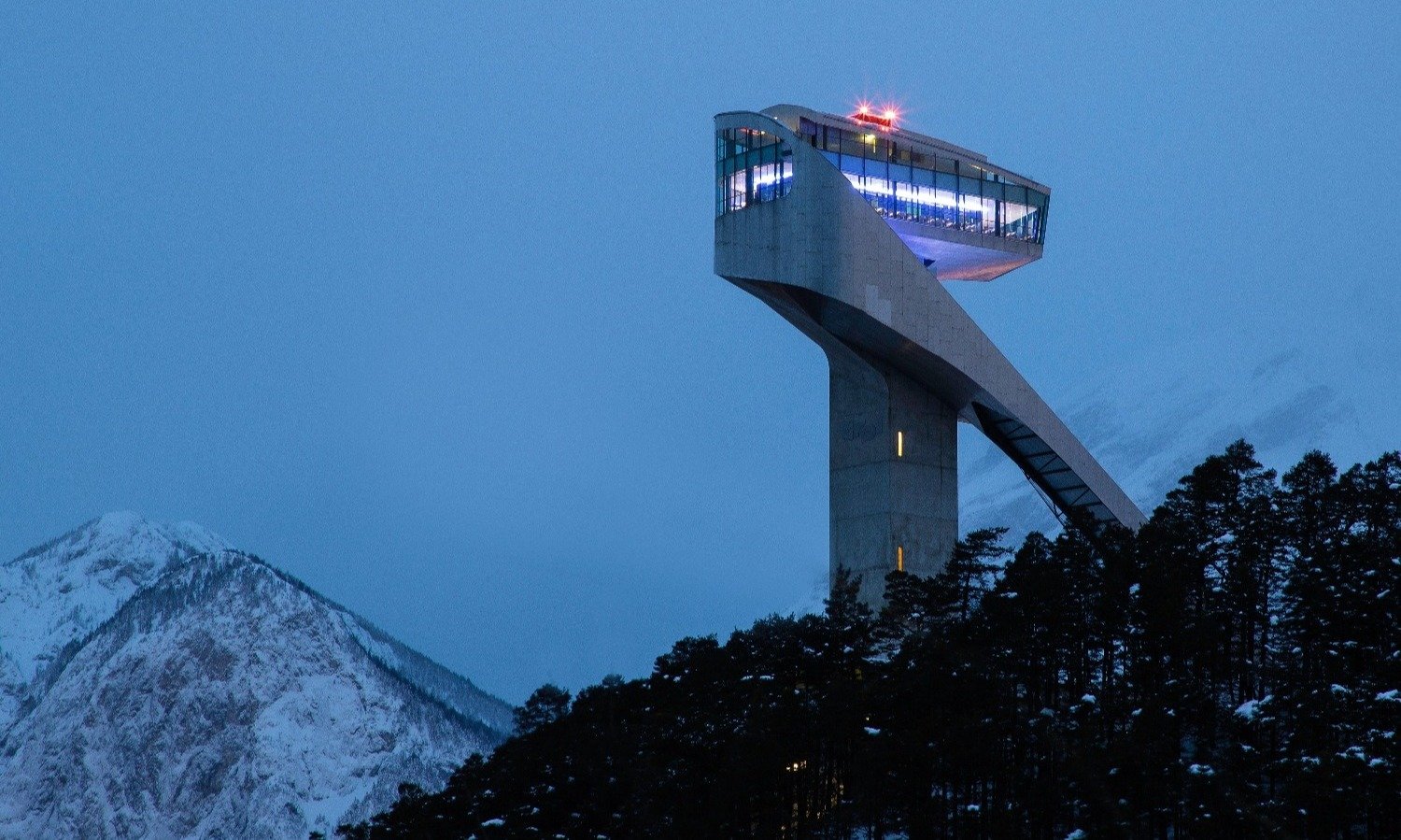 Air traffic control tower in the mountains emitting red light