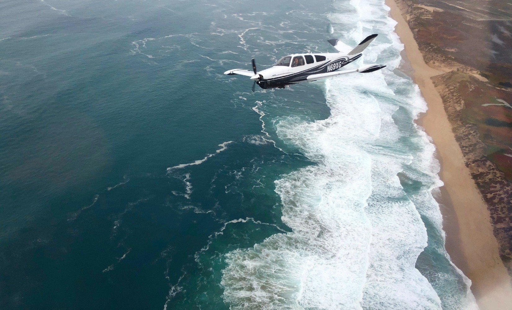 Flying a Beechcraft airplane over the coastline
