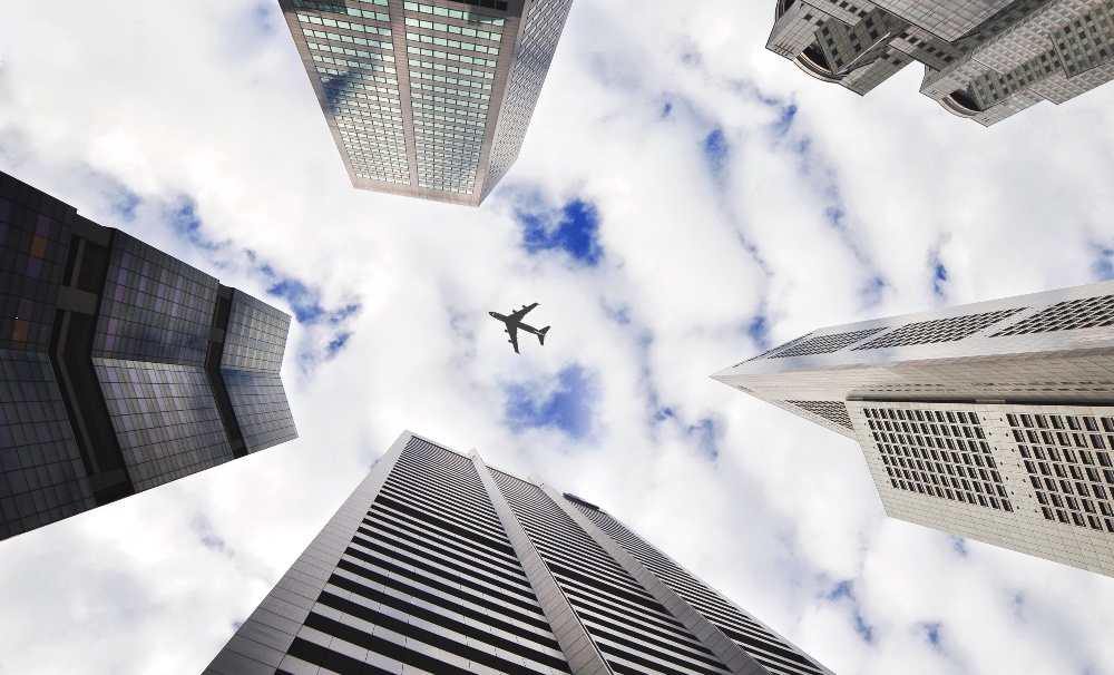 Commercial plane flying above skyscrapers