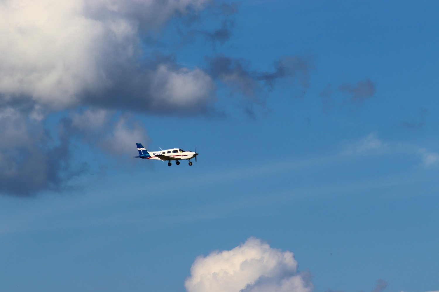 General aviation airplane flying away from clouds