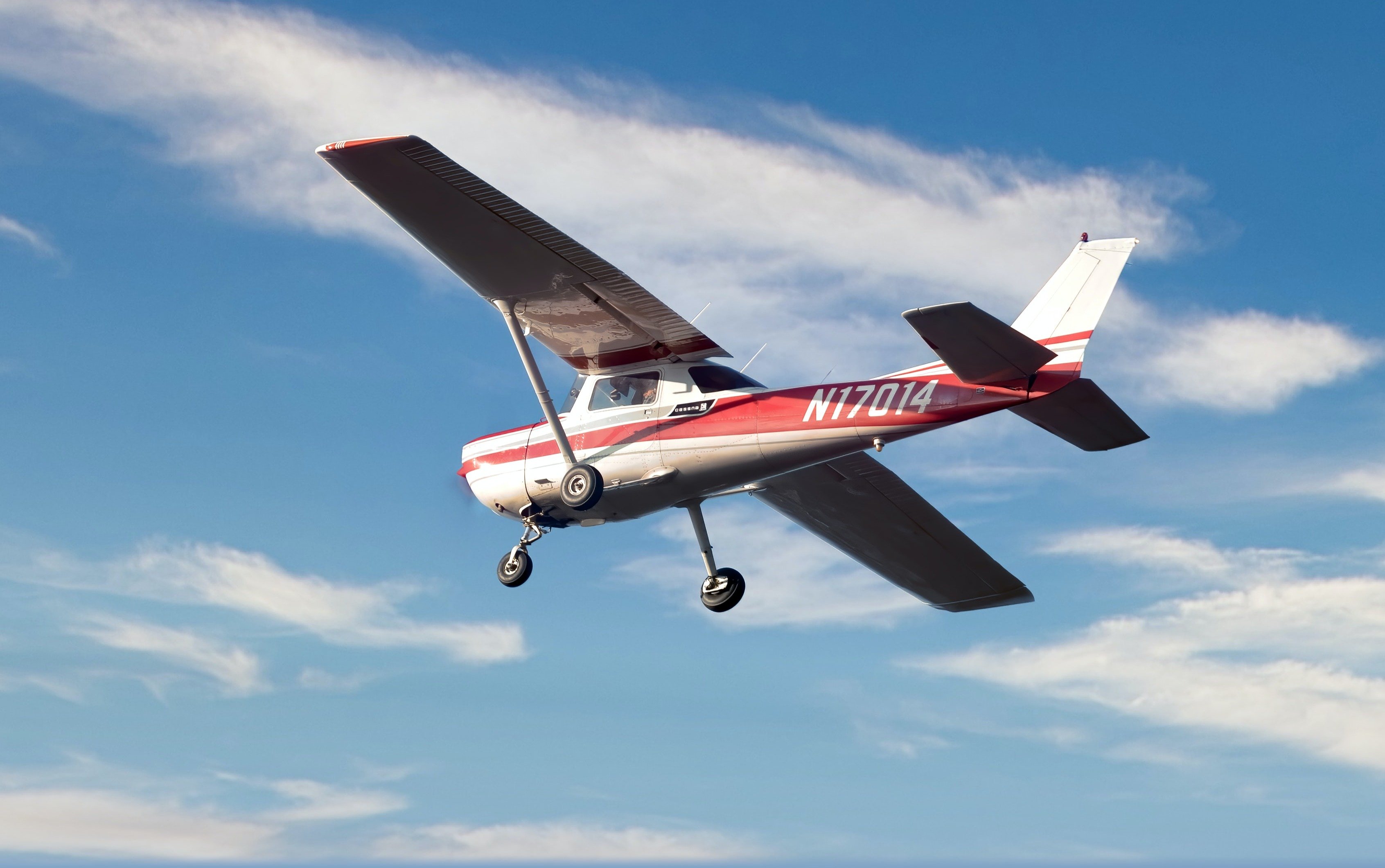 A high-wing general aviation plane flying in clear skies