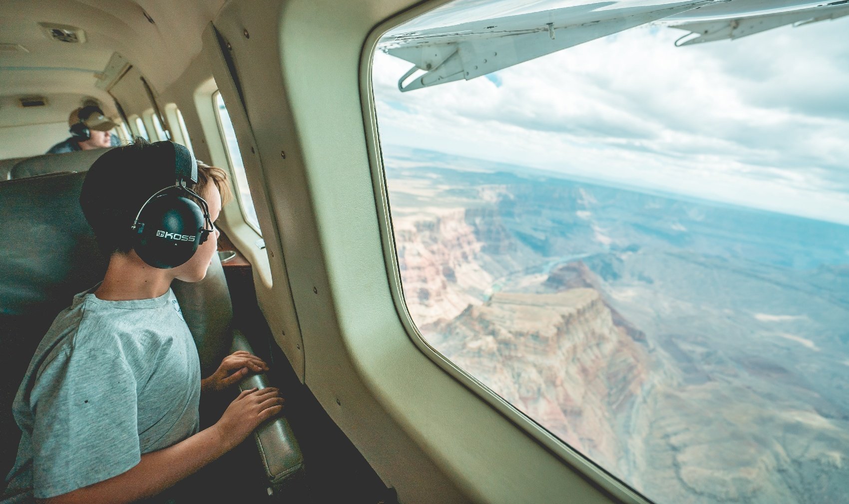A young boy looks out the window of a general aviation airplane during an aerial tour in Arizona
